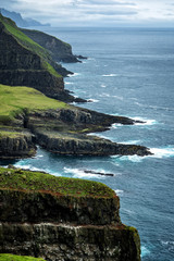 Landscape of giant sea cliffs overlooking the ocean at Mykines, Faroe Islands.