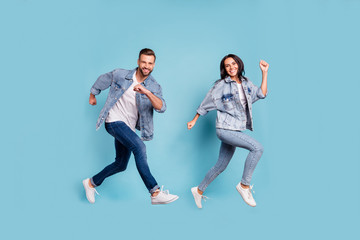 Fototapeta na wymiar Full length body size photo of rejoicing couple of friends running towards shopping mall for sales while isolated with blue background