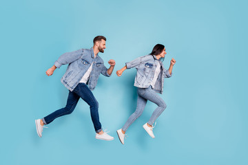 Fototapeta na wymiar Full length body size photo of funny enjoying nice good cute couple wearing jeans denim clothes having contests at fast running while isolated with blue background