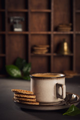 Cafe background with brown cup of coffee and dutch traditional cookies stroopwafels. Retro style toned.