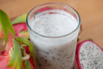 Dragon fruit smoothie on wooden table.