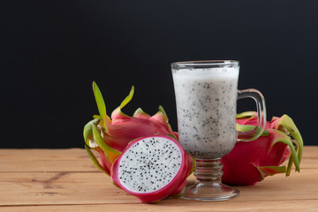 Dragon fruit smoothie on wooden table.
