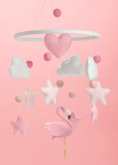 Colorful and eco-friendly children's mobile from felt for children. On pink background.