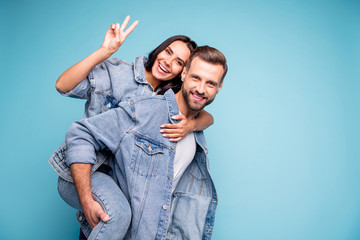Portrait of lovely guy carrying his passion making v-signs wearing denim jeans jacket isolated over...