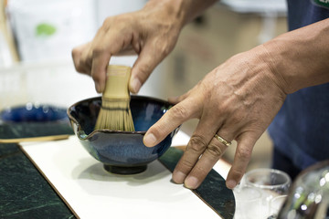 Stirring green tea with tea whisk