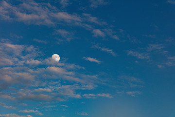 Beautiful full moon in the cloudy evening sky