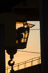 crane operator in the cab at sunset