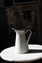 A pretty white vase with dried flowers