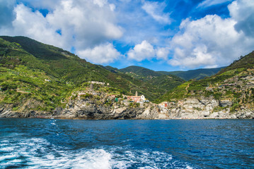 The rocky shore of Cinque Terre, overgrown with tropical greenery and vineyards. View from the sea, Monterosso al Mare, Italy