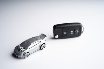 Obraz na płótnie Canvas Car loan, Insurance, buy and sell and Auto Finance conceptual image with Car Key remote, die cast car and dollar bills 