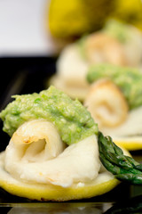 Flounder with asparagus puree ans sicilian lemon in a black plate