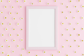 Top view of a pink frame mockup with daisy decoration on a pink background. Portrait orientation.