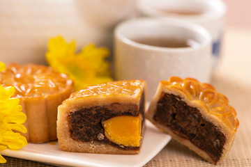 Mid-Autumn Festival holiday concept design of moon cake,mooncakes,tea set on bright wooden table and serving plate with copy space, close up.