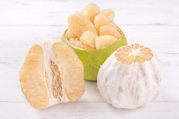 Fresh peeled pomelo, grapefruit, shaddock on bright wooden table background. Seasonal fruit for Mid-Autumn Festival, close up, copy space.