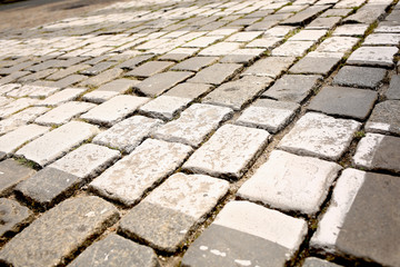 old pedestrian walkway on the street paved with stones
