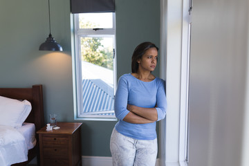 Senior woman standing with arms crossed at home
