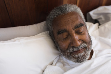 Senior man sleeping in bedroom at home