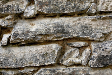 real stone wall of ancient stones of gray-beige color