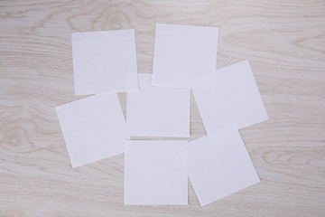 White empty post-it note posed on a wooden background