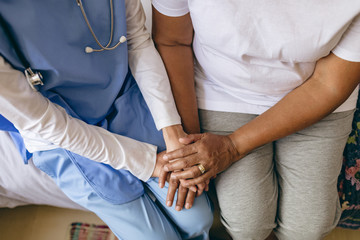 Fototapeta premium Female doctor holding hand of senior patient 