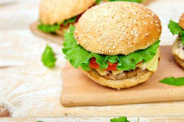 Craft beef burger  on wooden table on light background. Street food, fast food. Homemade juicy burgers with cheese and  on the wooden table. Copy space.