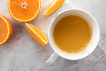 Top view of cut oranges and cup of fresh squeezed orange juice