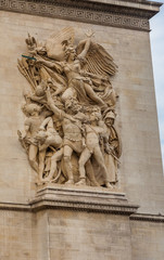 Fototapeta na wymiar Close view of main sculpture on the Arc de Triomphe's east pillar. Le Départ de 1792 or La Marseillaise by François Rude celebrates the French First Republic with a winged personification of Liberty. 