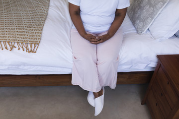 Thoughtful senior woman relaxing in bedroom at home