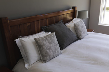 Table lamp and pillows arranged on a bed in bedroom