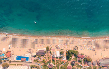 Aerial view of sandy beach with tourists swimming in beautiful clear sea water