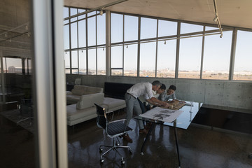 Business colleagues looking at house model