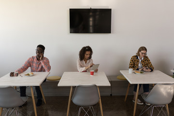 Business colleagues using digital tablet and talking on mobile phone in office 
