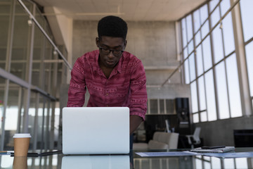 Male executive using laptop in office