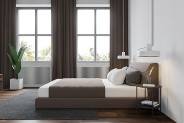 Side view of white bedroom with windows and TV