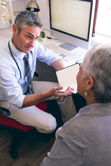 Fototapeta premium Male doctor and senior woman interacting with each other