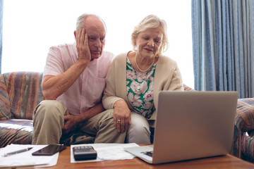 Couple looking medical report on laptop at retirement home