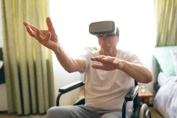 Senior male patient using virtual reality headset at retirement home