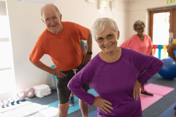 Fototapeta na wymiar Front view of senior couple exercising in fitness studio 