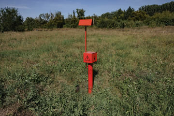Fototapeta na wymiar red electric cable stands in the field.