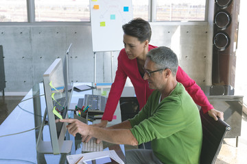 Attentive business people working at desk in creative office