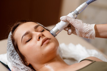 Lymphatic drainage massage LPG apparatus process. Therapist beautician makes a rejuvenating facial massage for the woman in a SPA salon. Beauty and bodycare concept.