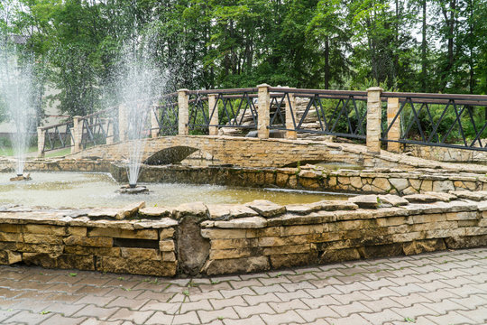 fountain and bridge of stone tiles in the Park. a decorative pond outdoors