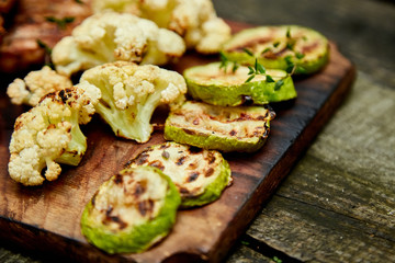 Grilled zucchini and cauliflower vegetable on wooden background . Vegan food. Diet, healthy Picnic. Summer. Top view. Flat lay. Copy space..
