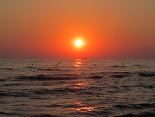 Sunset on the background of the sea in the haze.