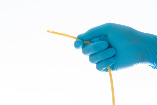 urethral catheter hold on blue glove hand on white background