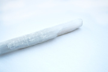 Selenite white crystal stick on white background