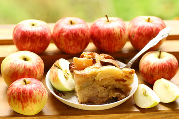 pieces of fresh baked apple pie among raw apples country style still life