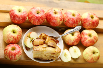Naklejka na ściany i meble pieces of fresh baked apple pie among raw apples country style still life