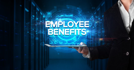 Young business person working on tablet and shows the inscription: EMPLOYEE BENEFITS, business concept