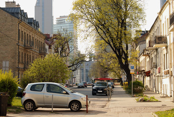 Fototapeta premium Street view of European city center with parked cars and greenery